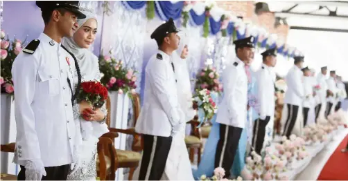  ??  ?? Unions in uniform: The 20 couples getting married at the police training centre in Kuala Lumpur. — Bernama