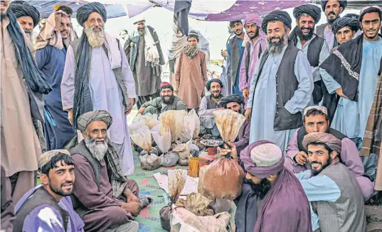  ?? ?? Heroin and hashish vendors at an opium market outside Kandahar are currently happy with their lot under the new regime