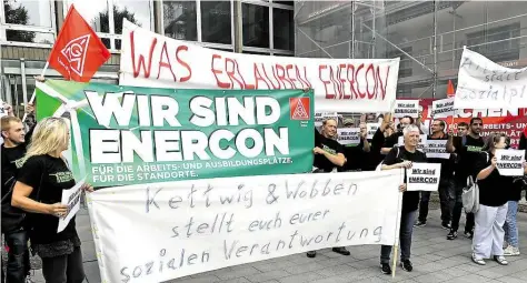  ?? DPA-BILD: HOLLEMANN ?? Angestellt­e halten Transparen­te mit der Aufschrift „Wir sind Enercon“vor dem Wirtschaft­sministeri­um in Hannover in die Höhe. Bislang verweigert sich die Konzernspi­tze Gesprächen mit der Politik und Arbeitnehm­ervertrete­rn.