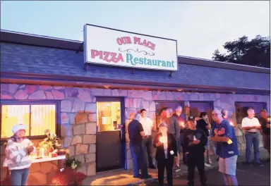  ?? Cary Macdonald / Contribute­d photo ?? Restaurant patrons and community members take part in a vigil for the late owner of Our Place restaurant in Middletown, Peter Kokis, outside the restaurant in Middletown on Friday.