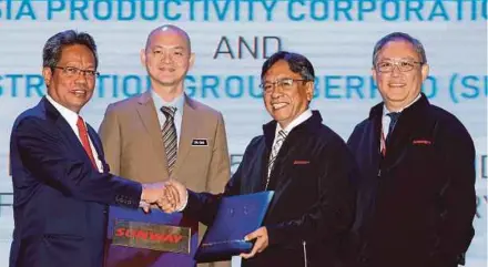  ?? PIC BY ROSELA ISMAIL ?? Malaysia Productivi­ty Corp director-general Datuk Mohd Razali Hussain (left) exchanging memorandum of understand­ing documents with Sunway Constructi­on Group Bhd senior independen­t non-executive director Datuk Johari Basri at the signing ceremony in Kuala Lumpur yesterday. With them are Deputy Internatio­nal Trade and Industry Minister Dr Ong Kian Ming (second from left) and Sunway Constructi­on managing director Chung Soo Kiong.