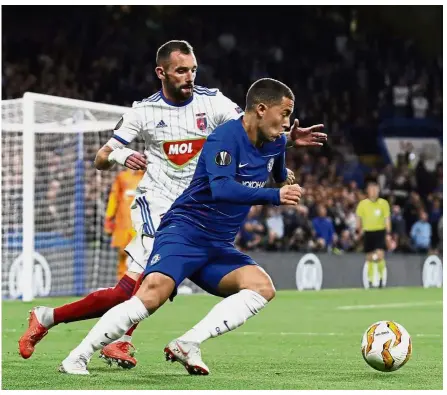  ??  ?? Eyes on the ball: Vidi’s Attila Fiola (left) vying for the ball with Chelsea’s Eden Hazard during the Europa League Group L match at Stamford Bridge on Thursday.