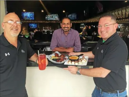  ?? GARY PULEO — DIGITAL FIRST MEDIA ?? With signature dishes at The Greene Turtle in East Norriton are, from left, manager Steve Bobinski, owner Pranav Desai and district manager Chris Fatale.