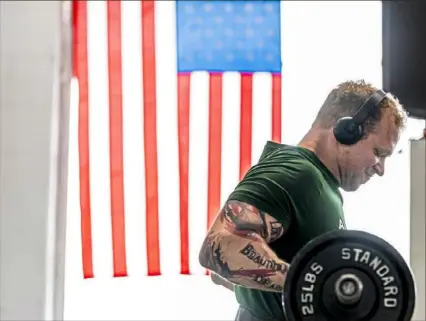  ?? Steph Chambers/Post-Gazette ?? Greg Barone, of Linesville, lifts weights Tuesday at Prep Training & Fitness Systems in Hermitage, Mercer County. Owner Joseph A. Joseph has reopened his gym despite the governor’s shutdown order.