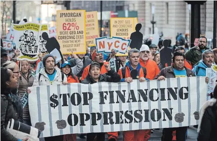  ?? DREW ANGERER GETTY IMAGES ?? Activists rally against financial institutio­ns’ support of private prisons and immigrant detention centers, as part of a May Day protest near Wall Street in Lower Manhattan, Tuesday in New York City. Across the world, people are protesting and marching...