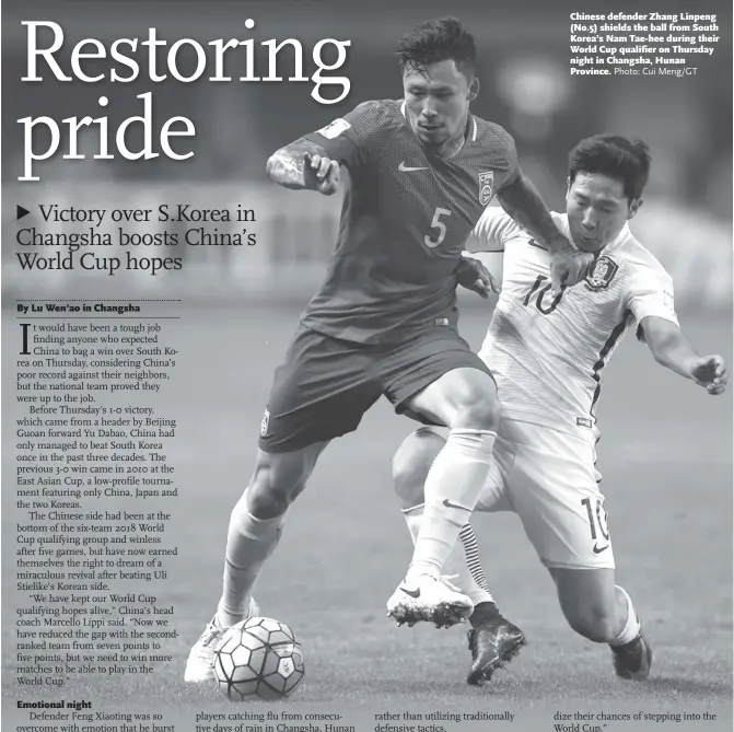  ?? Photo: Cui Meng/GT ?? Chinese defender Zhang Linpeng (No.5) shields the ball from South Korea’s Nam Tae-hee during their World Cup qualifier on Thursday night in Changsha, Hunan Province.