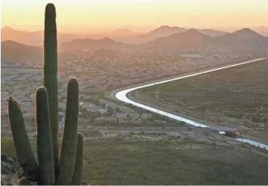  ??  ?? DAVID WALLACE/THE REPUBLIC The Central Arizona Project Canal winds through a neighborho­od on one side and the desert on the other in Phoenix as seen from the Deem Hills Recreation Area.