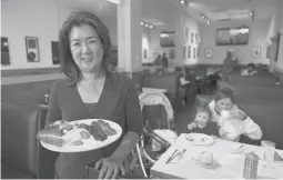  ?? ERIC RISBERG/AP ?? Jeannie Kim holds a popular bacon breakfast meal July 30 at her restaurant in San Francisco. A new law, which begins next year, “could be devastatin­g for us,” she says.