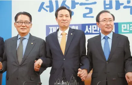  ?? Yonhap ?? Main opposition Democratic Party of Korea floor leader Rep. Woo Sang-ho, center, joins hands with People’s Party Rep. Park Jie-won, left, and Justice Party Rep. Roh Hoe-chan, ahead of a meeting at the National Assembly, Friday, on impeaching President...