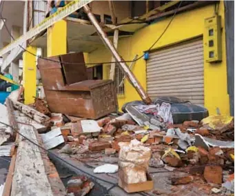  ?? AP ?? Residents of Machala, Ecuador (top), search through rubble (top and above) of quake that killed 15 people, injured close to 500 and leveled 300 buildings. The quake also hit northern Peru, killing a 4-year-old girl.