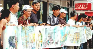  ??  ?? A section of over 30 artists from Malaysia and China pose with a 90-foot-long art piece depicting the streets, buildings, sceneries and people of Perak. — Bernama photo