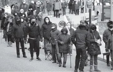  ?? SETH WENIG AP ?? People wait in line for the COVID-19 vaccine in Paterson, N.J., on Thursday. The first people arrived around 2:30 a.m. for the chance to be vaccinated at one of the few sites that does not require an appointmen­t.