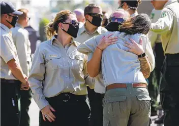  ?? IRFAN KHAN LOS ANGELES TIMES ?? San Bernardino National Forest officers Stephanie Childs (left), Samantha Gardner and Jill Moore comfort each other at a procession for fallen Big Bear Interagenc­y Hotshot Charles Morton on Tuesday.