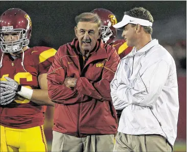  ?? STEPHEN DUNN / GETTY IMAGES ?? In 2010, Monte Kiffin (center left) was the USC Trojans’ defensive coordinato­r for son Lane Kiffin (right), then USC coach. Today the elder Kiffin is in a defense analyst role at Florida Atlantic under his son, now FAU coach.