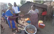  ?? MARK HOFFMAN / MILWAUKEE JOURNAL SENTINEL ?? A woman sells a mixture of chicken intestines and innards and eggs wrapped in sheets of used office paper for about 10 cents outside her home in the Korogocho slum. She has been making and selling the mixture for 30 years and was able to help pay for a...