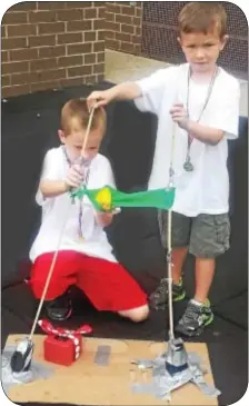  ??  ?? Brothers Noah (standing) and Josh Gould get ready to use their duck launcher at Council Rockís Camp Invention.