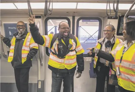  ?? Photos by Jessica Christian / The Chronicle ?? BART employees Walter Grier (left), Kevin Alexander, Charlotte Dangerfiel­d and Jessica Theus enjoy the new cars’ first run.