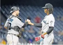  ?? JUSTIN K. ALLER/GETTY ?? Marlins closer Jose Urena celebrates with catcher Bryan Holaday after defeating the Pirates at PNC Park on Tuesday night in Pittsburgh.