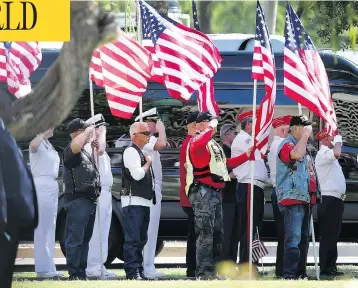  ?? RALPH FRESO / GETTY IMAGES ?? Military personnel and veterans salute as the funeral procession for Sen. John McCain arrives Wednesday at the Arizona State Capitol in Phoenix. McCain, a decorated war hero, died Saturday after a long battle with brain cancer.