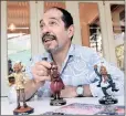  ?? PICTURE: NOKUTHULA MBATHA ?? GRAPHIC ACTIVIST: Cartoonist Jonathan Shapiro, famous as Zapiro, holds figurines with his latest book, Dead President Walking, during an interview.