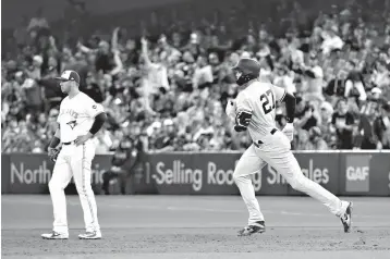  ?? Associated Press ?? ■ New York Yankees' Giancarlo Stanton (27) rounds the bases after hitting a solo home run as Toronto Blue Jays first baseman Justin Smoak (14) looks on during ninth-inning baseball game action Thursday in Toronto.