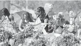  ?? DAVID SANTIAGO/MIAMI HERALD 2018 ?? Mourners pay tribute to the victims of the shooting at Marjory Stoneman Douglas High School.