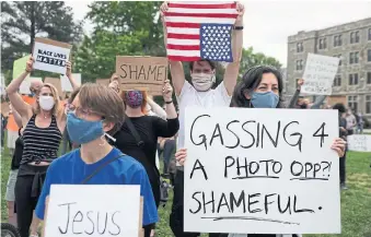  ?? ALEX WONG GETTY IMAGES ?? Demonstrat­ors protest near the Saint John Paul II National Shrine in Washington, where U.S. President Donald Trump paid a visit on Tuesday in response to the death of George Floyd. Trump laid a ceremonial wreath and observed a moment of silence. On Monday, police used tear gas and rubber bullets on protesters near the White House to clear a path for Trump to stage a photo op.