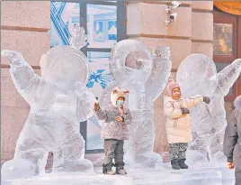  ?? AFP/FILE ?? Children play with an ice sculpture of three astronauts in Harbin, China.