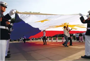  ?? AP FOTO ?? INDEPENDEN­CE
DAY. Marines prepare to raise the flag to celebrate the 119th anniversar­y of Philippine independen­ce at Rizal Park while fighting continues in Marawi, with Philippine troops getting assistance from the United States.