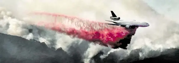  ?? DPA-BILD:VOGEL ?? Eine McDonnell Douglas DC-10 lässt Löschmitte­l über einem Waldbrand in den Bergen nahe der Malibu Canyon Road ab.
