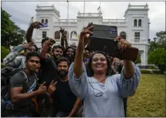  ?? ?? Protesters take a photograph as they leave prime minister Ranil Wickremesi­nghe’s office building.