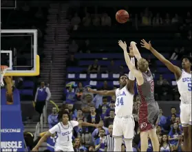  ?? PHOTO/ ?? Utah guard Parker Van Dyke (5) makes a winning three-point basket over UCLA guard Chris Smith (5) and guard David Singleton (34) as time expires during the second half of an NCAA college basketball game on Saturday, in Los Angeles. AP MARCIO JOSE SANCHEZ