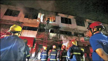  ?? MIGUEL DE GUZMAN ?? Firefighte­rs respond to a fourth alarm fire that razed a building in Paco, Manila on Friday.