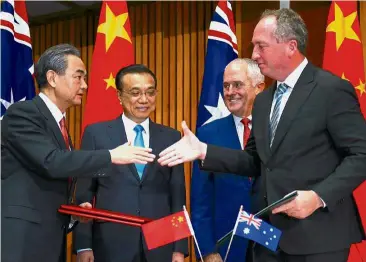  ?? — Reuters ?? Moving forward: Chinese foreign minister Wang Yi and Australian Deputy Prime Minister and Minister for Agricultur­e and Water Resources Barnaby Joyce sealing a deal at Parliament House in Canberra. Looking on are Li and Turnbull.