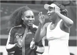  ?? Chuck Burton/The Associated Press ?? ■ Venus Williams, right, and Serena Williams, left, celebrate after defeating Netherland­s in the first round of Fed Cup tennis competitio­n in Asheville, N.C.