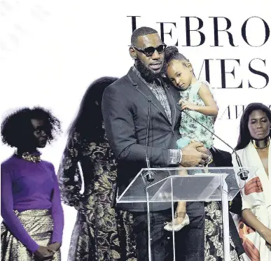  ?? AP ?? Basketball star LeBron James holds his daughter, Zhuri, as he accepts Harlem Fashion Row’s ICON 360 Award for his contributi­on to fashion and philanthro­py at the HFR fashion show and awards ceremony before the start of New York Fashion Week on Tuesday.