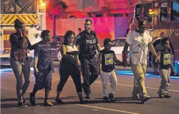  ?? [FRANK GUNN/THE CANADIAN PRESS VIA AP] ?? Police escort civilians away from the scene of a shooting Sunday in Toronto.