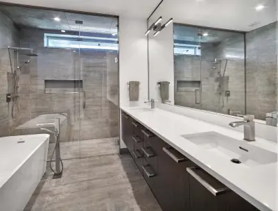  ??  ?? The large shower of the master ensuite hosts curbless appeal with bench seating and a clerestore­y window for natural light. The freestandi­ng bath is enhanced with floormount­ed, stainless steel faucets opposite the floating, dual vanity of consistent...