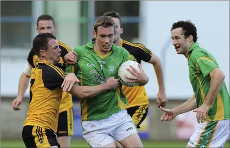  ??  ?? Ashford’s Jason Taylor tires to halt the run of Kilcoole’s Ronan Keddy.