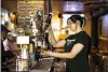  ?? MATT ROURKE — THE ASSOCIATED
PRESS ?? A bartender pours a beer Thursday in McMenamin’s Tavern in Philadelph­ia.