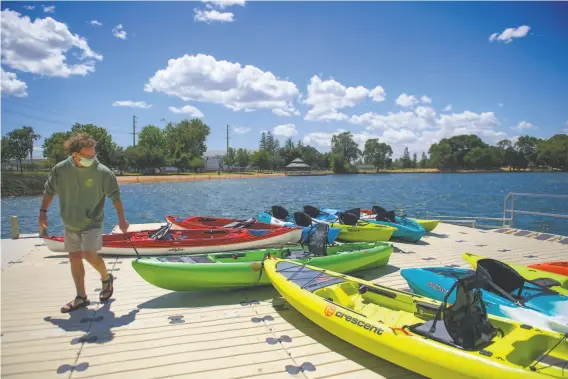  ?? PHOTOS BY CHRIS KAUFMAN ?? Headwaters Kayak employee Quin Murphy works on the dock at Lodi Lake Boathouse. The business offers kayak and standup paddleboar­d rentals, tours and lessons.