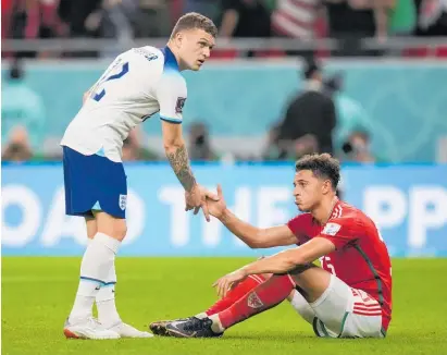  ?? Photos / AP ?? England’s Kieran Trippier shakes hands with a despondent Ethan Ampadu after England’s 3-0 win.