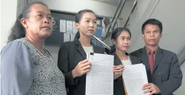  ?? CHANAT KATANYU ?? Wanalee Thunmak, second left, and Nirawan Cheuboonme­e, third left, show complaint letters they submitted to the Education Ministry demanding justice for being refused jobs as assistant teachers after having taught in Tak for five months without pay.