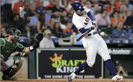  ??  ?? Houston Astros’ George Springer (right) connects for a two run home run in front of Oakland Athletics catcher Chris Herrmann (left) during the third inning of a baseball game on Wednesday, in Houston. AP PHOTO/MICHAEL WYKE