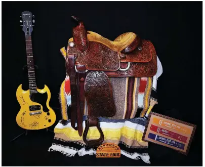  ?? Courtesy Old State House Museum ?? The 1966 rodeo queen saddle, a guitar signed by Creedence Clearwater Revival and ribbons from the 1918 State Fair in Jonesboro are part of the exhibit “80 Blue Ribbon Years: Cotton to Cattle.”