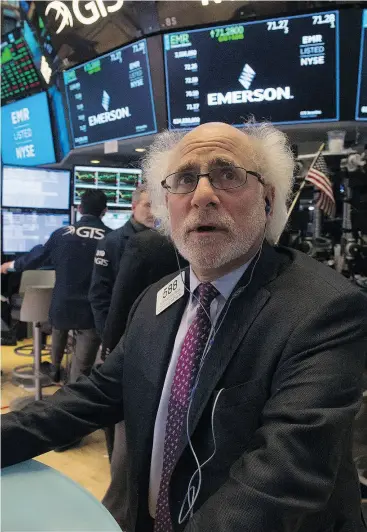  ?? BRYAN R. SMITH / AFP / GETTY IMAGES ?? A trader at the Dow Industrial Average at the New York Stock Exchange, where an analyst warns investors to expect “the whooshes and ramps” to continue.