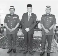  ?? ?? KUNJUNGAN HORMAT: Tun Wan Junaidi (tengah) merakamkan kenangan ketika menerima kunjungan hormat daripada Mohd Sofi (kiri) yang ditemani Kolonel Mohd Rizman Ramli.
