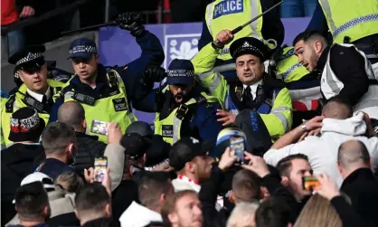  ?? ?? Police officers in the stands use batons against Hungary. Photograph: Facundo Arrizabala­ga/EPA