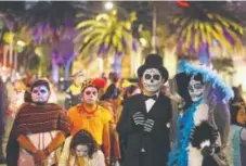  ?? Rebecca Blackwell, The Associated Press ?? People dressed as Mexico’s iconic Catrina march in the Grand Procession of the Catrinas, part of upcoming Day of the Dead celebratio­ns, in Mexico City on Oct. 22.