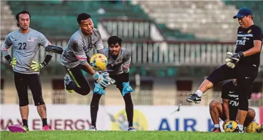  ?? [FOTO OSMAN ADNAN/BH] ?? Khairul Fahmi, Khairul Azhan dan Hafizul Hakim menjalani latihan dibimbing jurulatih penjaga gol, Kris Yong Wai Hwang di Stadium Aung San menjelang aksi kejohanan Piala Suzuki AFF 2016 yang bermula esok.